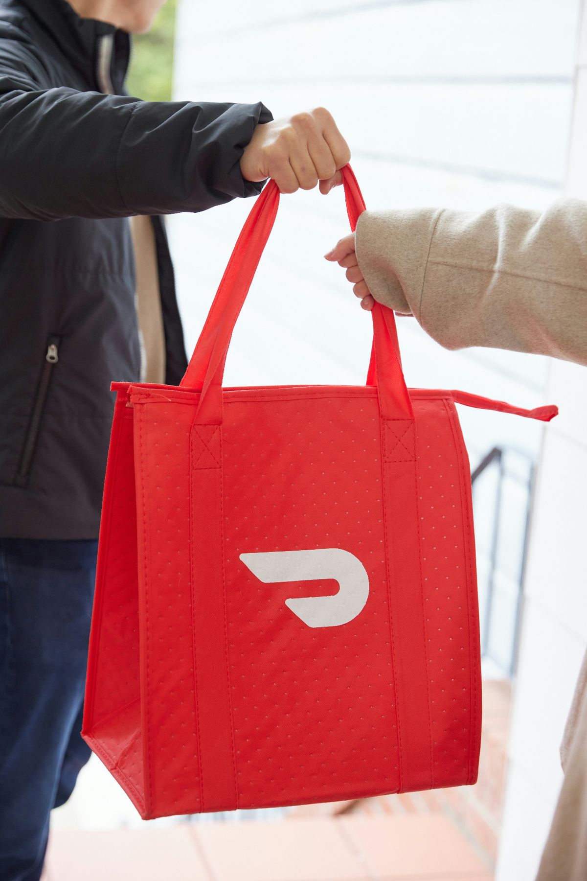 DoorDash delivery handover with insulated red bag